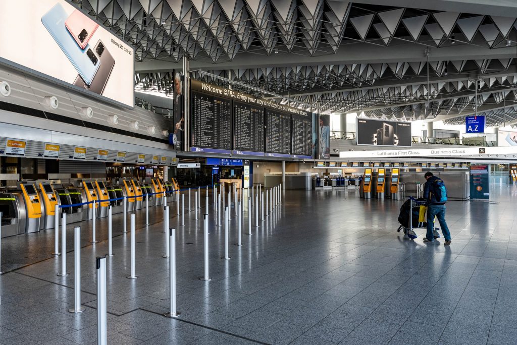 empty airport showing one passenger traveling to his gate. coronavirus image